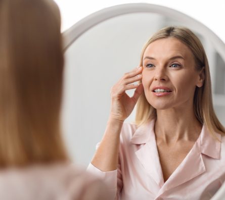 Closeup Shot Of Middle Aged Beautiful Woman Looking In Mirror At Home Closeup Shot Of Middle Aged Beautiful Woman Looking In Mirror At Home