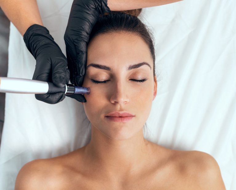 Cosmetologist making mesotherapy injection with dermapen on face for rejuvenation on the spa center.