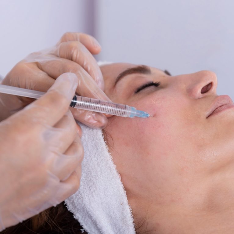 portrait of a young woman receiving facial mesotherapy treatment to smooth wrinkles.